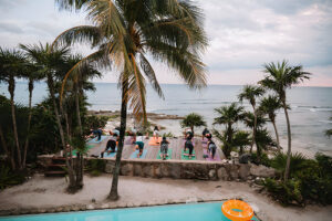 Group yoga session on tropical beach deck