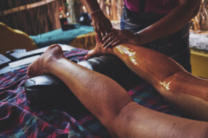 Person receiving oil leg massage at spa