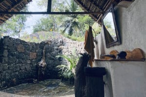 Rustic outdoor bathroom with stone walls and plants