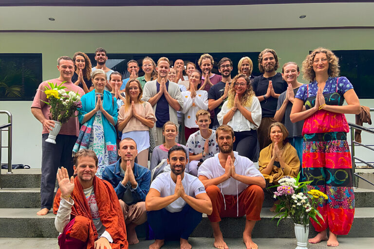 Group posing with hands in prayer on steps