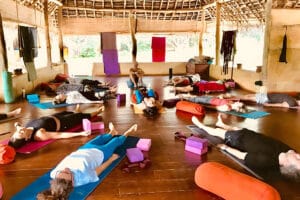 Yoga class resting in open-air wooden studio