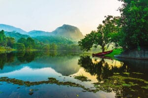 Red boat on serene mountain lake at sunrise