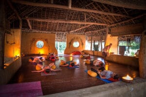 People relaxing during candlelit yoga class indoors